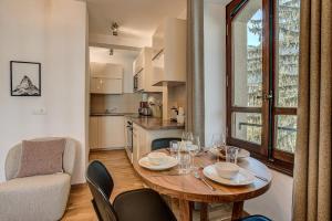 Una cocina y un comedor con mesa y sillas. en Apartment La Roseraie - Alpes Travel - Central Chamonix (sleeps 2-3), en Chamonix-Mont-Blanc