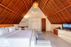 ein Schlafzimmer mit einem Bett und einem Flachbildfernseher in der Unterkunft Kanaka Cottage by Bukit Vista in Uluwatu + 14 Fotos