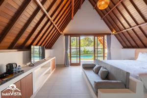 ein Schlafzimmer in einer Villa mit einem Bett und einem Sofa in der Unterkunft Kanaka Cottage by Bukit Vista in Uluwatu