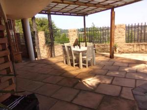 un patio avec une table et des chaises sur un patio dans l'établissement Sunset Cottage - Own Water - Own Electricity, à Pretoria