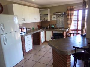 une cuisine avec un réfrigérateur blanc et une table dans l'établissement Sunset Cottage - Own Water - Own Electricity, à Pretoria