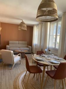 a living room with a table and chairs and a couch at Bel appartement en centre-ville de Cambrai in Cambrai