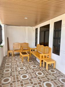 a porch with two wooden chairs and a table at House in Davao for rent in Davao City +12 photos