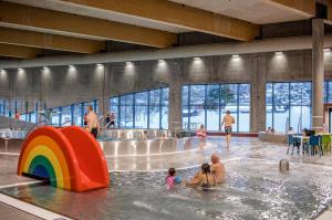 a group of people playing in a swimming pool at Spacious 3-Bedroom Apartment with Balcony and Free Parking Orkland near Trondheim in Fannrem