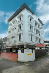 a white building with a fence in front of it at Orient Glory - Walk to Lulumall & Metro in Edappally