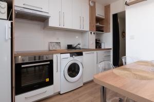 a kitchen with a washer and dryer and a table at L'Océanic vue mer, Draps et parking in Arzon +15 photos