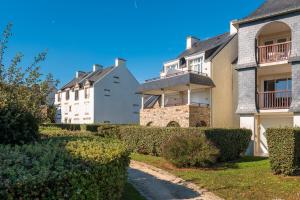 a row of houses with bushes in front of them at L'Océanic vue mer, Draps et parking in Arzon