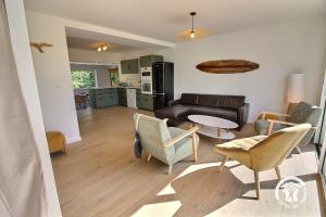 a living room with a couch and chairs and a table at Ty gouldri in Saint-Quay-Perros +17 photos