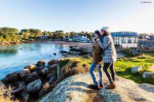 een man en een vrouw staan op een rots met uitzicht op een rivier bij Ty gouldri in Saint-Quay-Perros