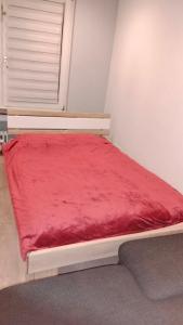 a bed with a red blanket on it in a room at Nastaran Nest in Oberhausen