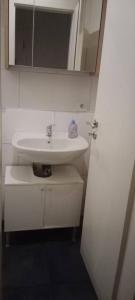 a bathroom with a white sink and a mirror at Gemütliches Zimmer mit gemeinsamem WC in Oberhausen Osterfeld-Mitte in Oberhausen