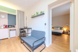 un salon avec une chaise et un lit dans l'établissement Le due dimore di Corso Torino, à Novara