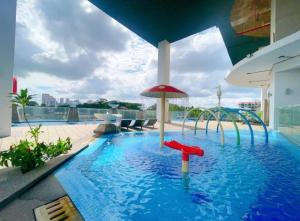 a swimming pool with an umbrella in a building at GYDEN STAYCATION #Straits Suites & Residences in Johor Bahru