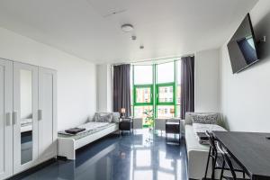 a living room with white furniture and a large window at Apartmenthaus in Halle-Saale nähe Hauptbahnhof in Halle an der Saale