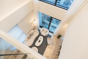 an open living room with two white chairs and tables at Caelum Black Gangnam Luxury Residence in Seoul