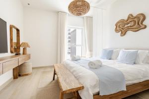 a white bedroom with a large bed and a wooden table at The Surfer's Yas 2BR plus Study Apartment, Full canal & pool view, Theme Parks Yas in Yas Island