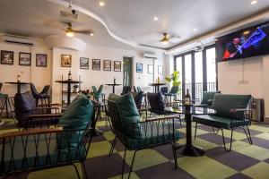 a bar with green chairs and a table in a room at Times Hotel at Bassac Lane in Phnom Penh
