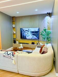 Una sala de estar con un sofá y un televisor en The Urbanshortlet, en Moba