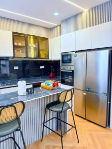 cocina con encimera con 2 sillas y nevera en The Urbanshortlet, en Moba