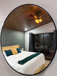 Pozas y Cascadas La Presa Habitación 4 في Río Cuarto: مرآة تعكس غرفة نوم مع سرير وسقف