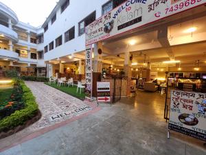 a lobby of a building with tables and chairs at Hotel Kolam in Shānti Niketan +46 photos