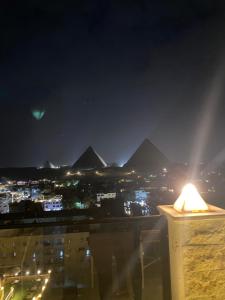 a view of the pyramids at night from a building at Pyramids Night Hotel &Free pickup shuttle in Giza