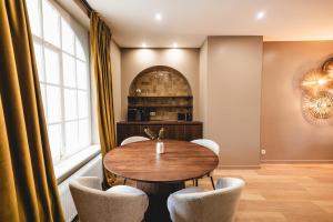 a dining room with a wooden table and chairs at Le Cocon Dinantais - romantic and elegant stay in Dinant