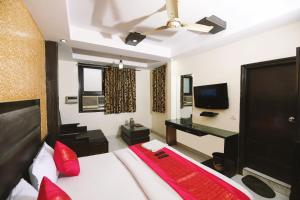 a bedroom with a bed with red pillows and a desk at Hotel Lav-kush Deluxe 2 Min From New delhi Railway Station in New Delhi