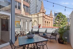 シドニーにあるSplit Level City Loft with Private Balconyのバルコニーにテーブルと椅子が置かれたパティオ