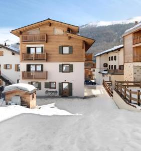 a building with snow on the ground in front of it at Sunrise Livigno in Livigno