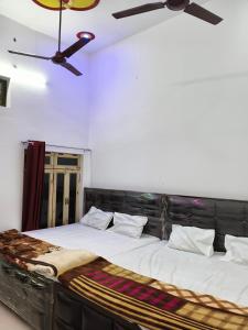NaimishāranyaMa vindhyavasini Atithi Bhavan的房间里有一张大床，配有吊扇