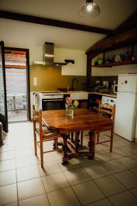 a kitchen with a wooden table with flowers on it at La Fournière de Jean - La Téouleyre in Saint-Julien-en-Born