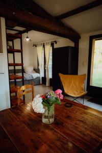 a vase of flowers sitting on a wooden table at La Fournière de Jean - La Téouleyre in Saint-Julien-en-Born