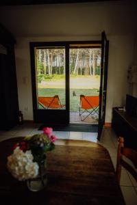 a room with a window and a table with flowers at La Fournière de Jean - La Téouleyre in Saint-Julien-en-Born