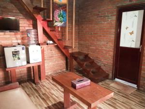 a room with a wooden staircase with a table and a brick wall at D'Tebe House Kelating in Tabanan +11 photos