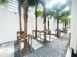 a row of palm trees in a room with chairs at UTD8 Hotel and Residence in Bangkok
