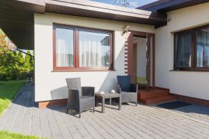 ein Haus mit Stühlen und einem Tisch auf einer Terrasse in der Unterkunft U Derca in Gnieżdżewo