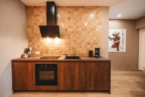 a kitchen with a counter with a sink and a stove at Le Cocon Dinantais - romantic and elegant stay in Dinant