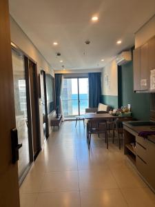 a kitchen and living room with a table and a dining room at The Sóng Homestay Vibes by the Sea in Vung Tau
