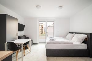a room with a bed and a table and a desk at Homaris Apartments Therese in Munich