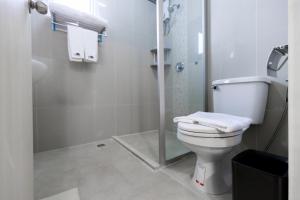 a bathroom with a toilet and a glass shower at UTD8 Hotel and Residence in Bangkok