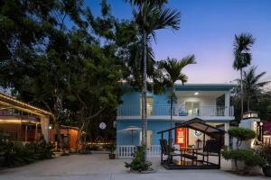 a blue house with a porch and palm trees at Haishu Yuntian 