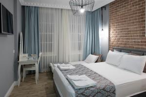 1 dormitorio con 1 cama y escritorio con ordenador en Luna Hotel Kaleiçi en Antalya