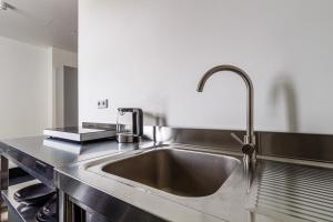 a kitchen sink with a faucet on a counter at Apartmenthaus in Halle-Saale nähe Hauptbahnhof in Halle an der Saale +131 photos