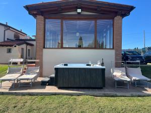 un patio con bañera de hidromasaje y 2 sillas en Villacolle 1, Poggio a Caiano, en Poggio a Caiano