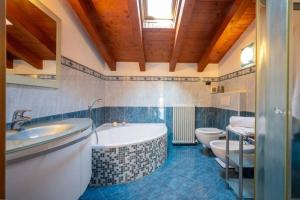 a bathroom with a tub and a toilet and a sink at Art Music House Lake Como Beach 5 minutes walk in Dongo +38 photos