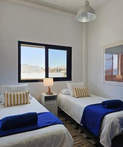 a bedroom with two beds and a window at La Gaeta 1,Views above the Ocean in Telde