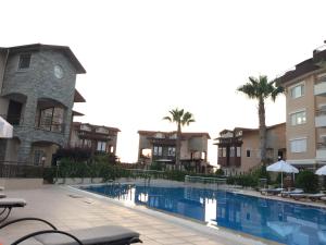 a pool at a hotel with palm trees and buildings at Elite Penthouse in Avsallar