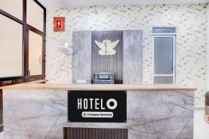 Un mostrador de recepción con un cartel de hotel en la pared. en Super Hotel O Neopolis Mall Ludhiana Formerly Silver Sky, en Ludhiana