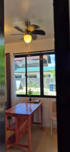 Un comedor con una mesa y un ventilador de techo. en GBoy Guest House, en General Luna 3 fotos más